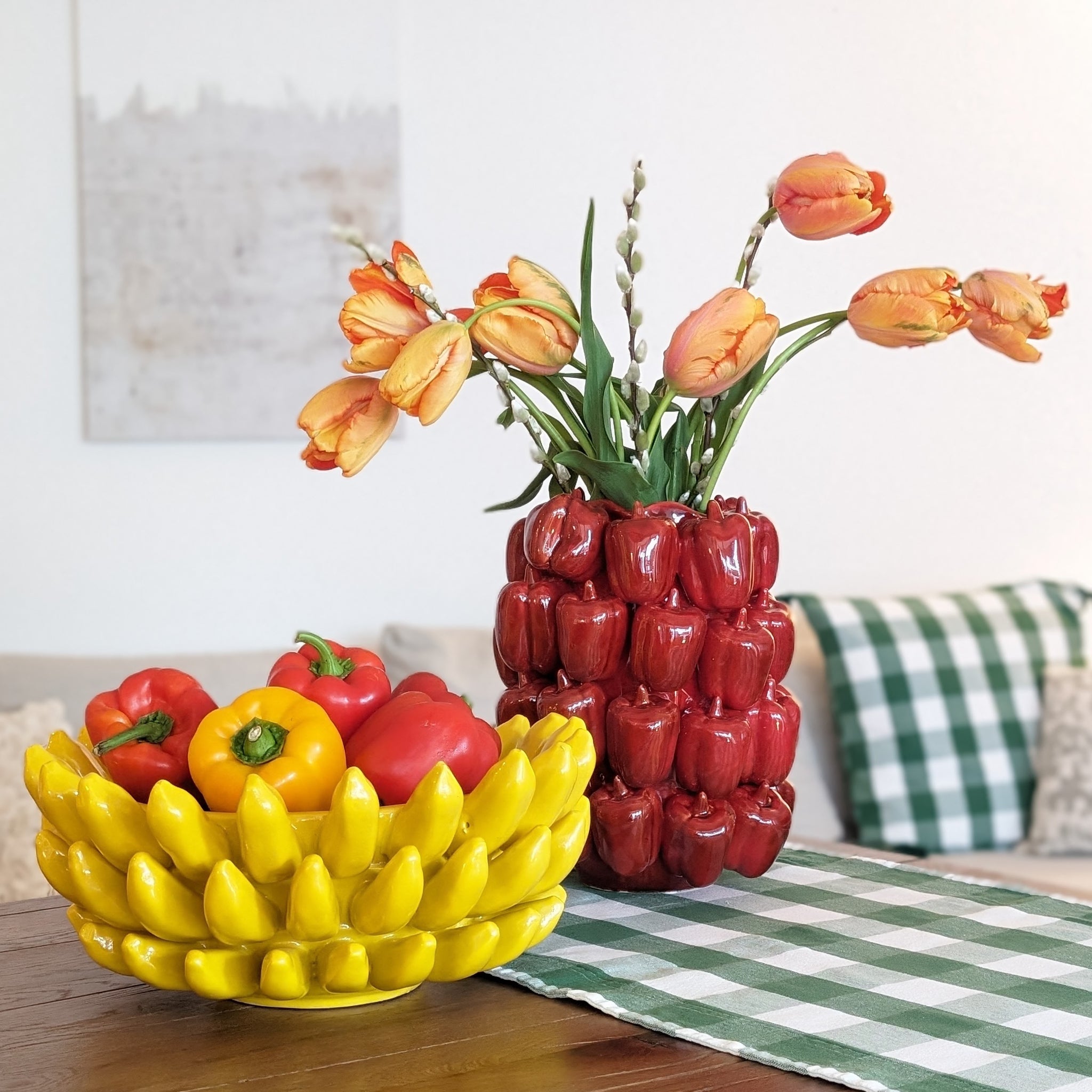 Moodbild mit gelber Früchteschale aus Kermaik in Bananenmotiv und Vase aus Keramik in Peperonimotiv