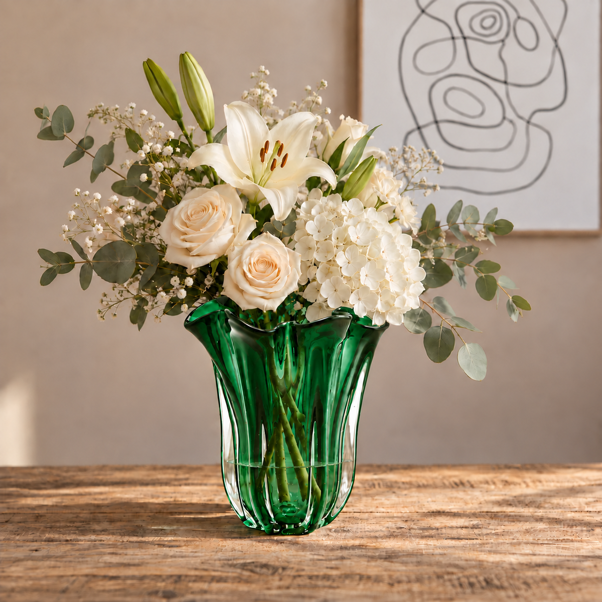 Grüne Glasvase Maelle in Tulpenform mit weissen Rosen, Lilien und Eukalyptus auf einem Holztisch