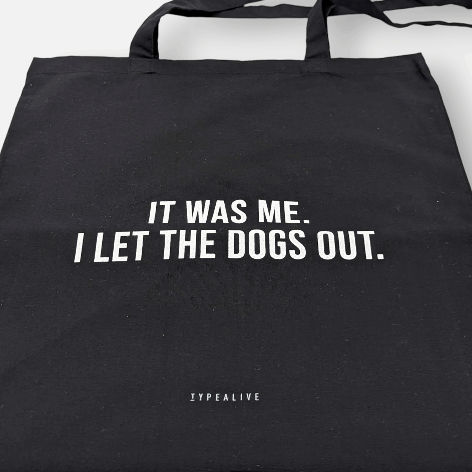 Tote Bag, Einkaufstasche aus Baumwolle schwarz, mit Schriftzug „It was me. I let the dogs out.“ – von Typealive